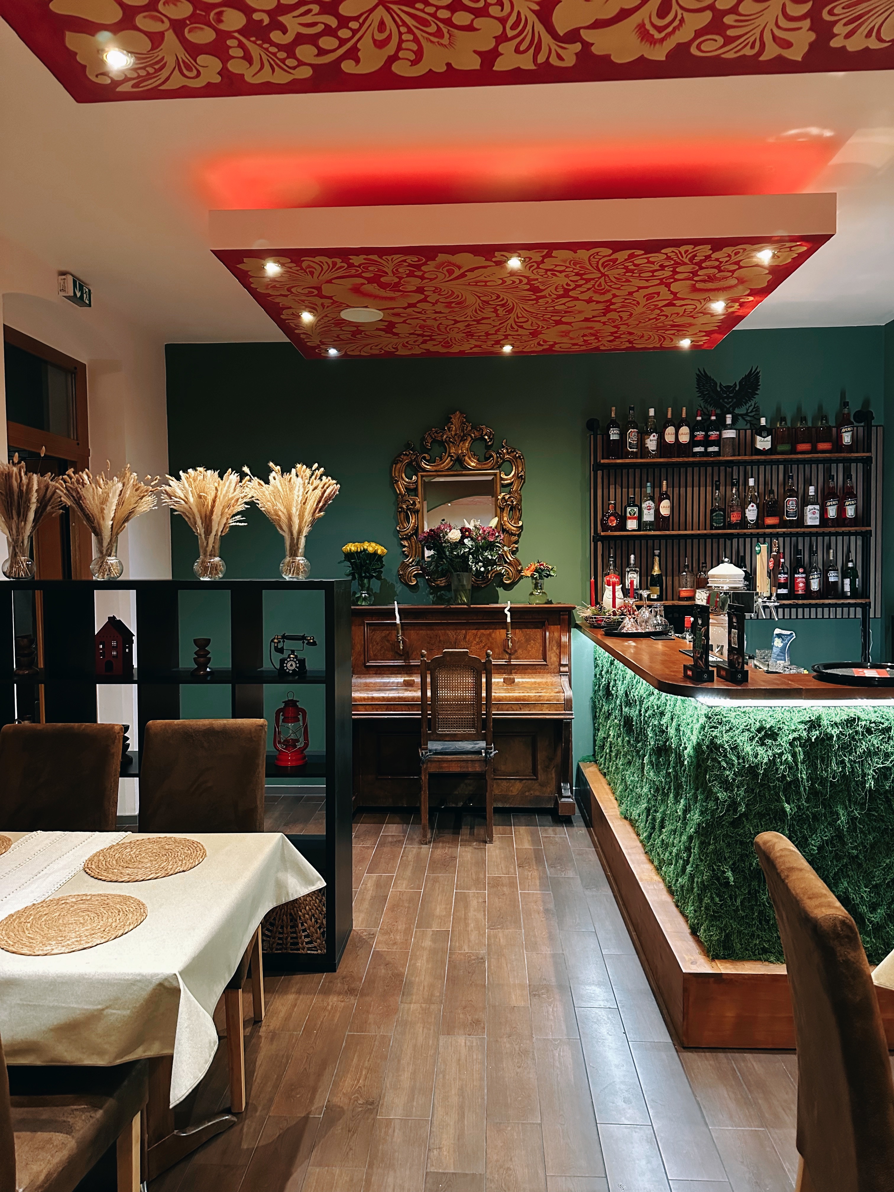 Unsere Bar mit Klavier und goldenem Spiegel